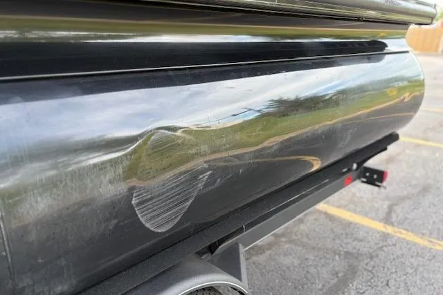Slide: The Image of 2024 Regency 250 DL3 pontoon boat with visible dent on the side. - 20
