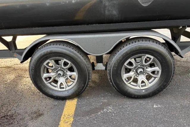 Slide: The Image of 2024 Regency 250 DL3 trailer wheels on asphalt surface. - 23