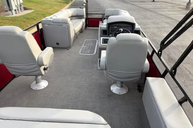 Slide: The Image of 2024 Regency 250 DL3 pontoon boat interior with gray seating and steering console. - 36