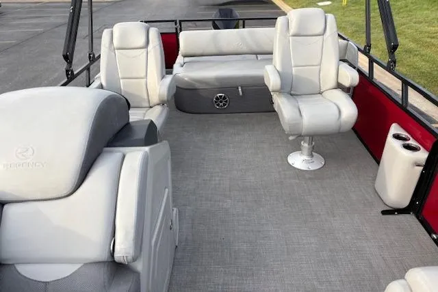 Slide: The Image of 2024 Regency 250 DL3 pontoon boat interior with gray seating and red accents. - 44