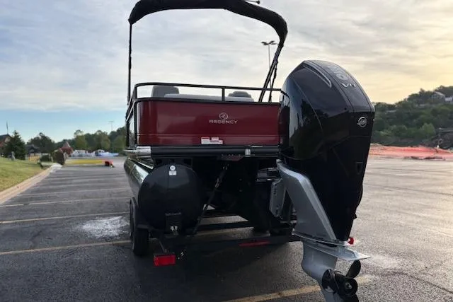 Slide: The Image of 2024 Regency 250 DL3 pontoon boat with outboard motor in parking lot. - 7