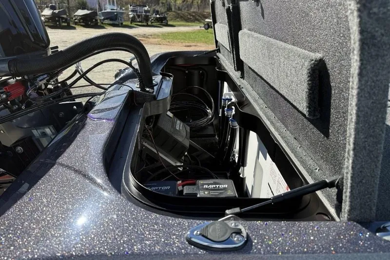 Slide: The Image of Open storage compartment of 2026 Skeeter ZXE21 boat, showing internal components and wiring. - 21