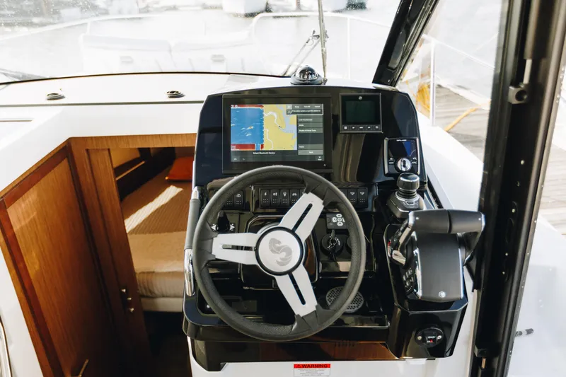 Slide: The Image of 2026 Beneteau Antares 9 helm with navigation display and steering wheel. - 12