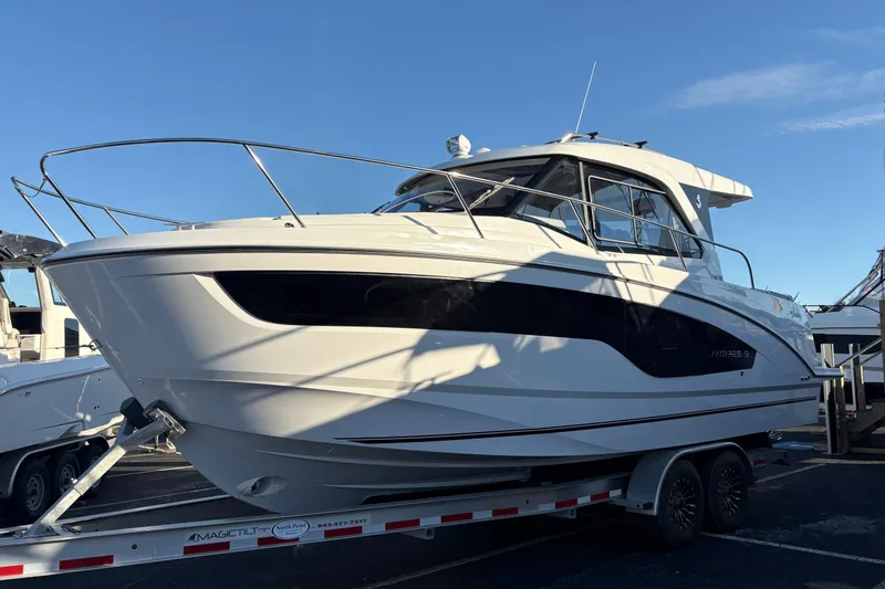 Slide: The Image of 2026 Beneteau Antares 9 boat on trailer, sleek design under clear blue sky. - 2
