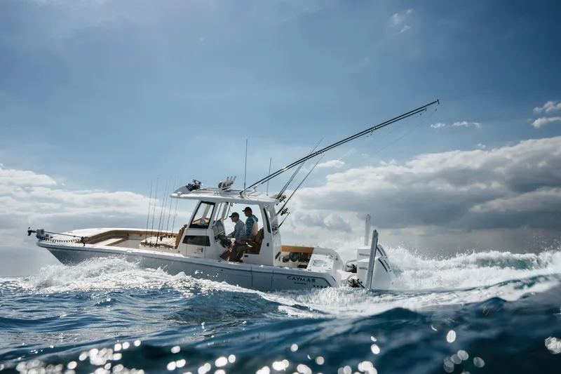 Slide: The Image of Caymas 29 CT 2027 boat navigating rough seas under a blue sky. - 21