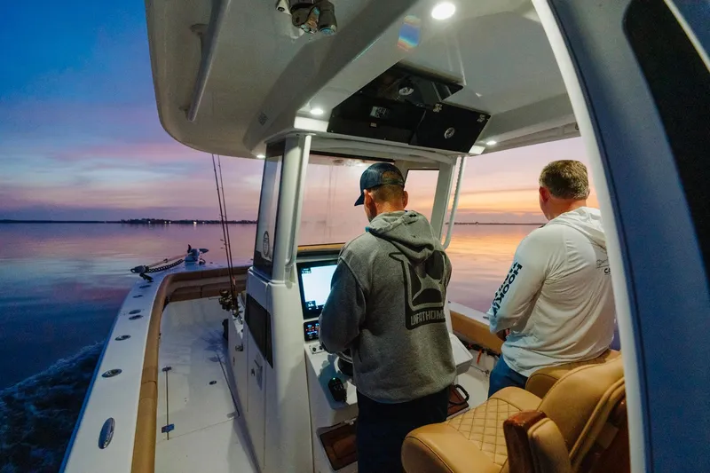Slide: The Image of Two men on a Caymas 29 CT boat at sunset. - 22