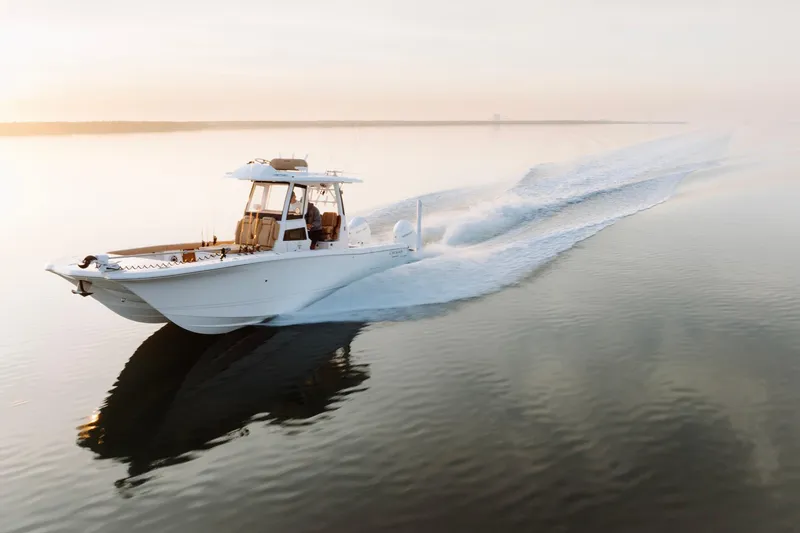 Slide: The Image of Caymas 29 CT 2027 boat cruising on calm water at sunset. - 3