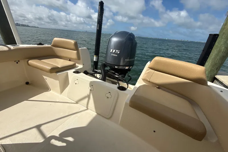 Slide: The Image of 2021 Scout 195 Sportfish boat interior with Yamaha 115 engine, docked by the sea. - 11