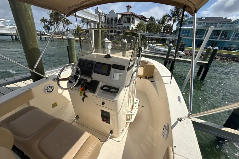 Slide: The Image of 2021 Scout 195 Sportfish boat docked, featuring a sleek console and comfortable seating. - 3