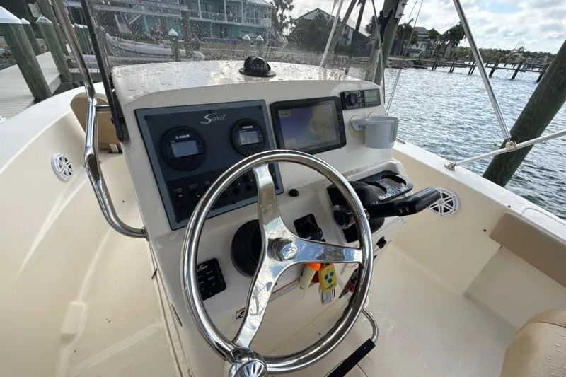Slide: The Image of 2021 Scout 195 Sportfish boat dashboard with steering wheel and navigation instruments. - 4