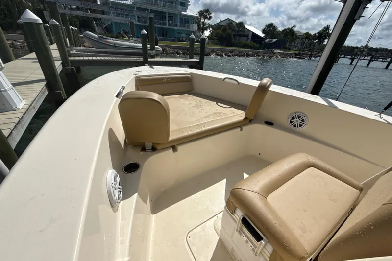 Slide: The Image of 2021 Scout 195 Sportfish boat interior with beige seating at a dockside location. - 7