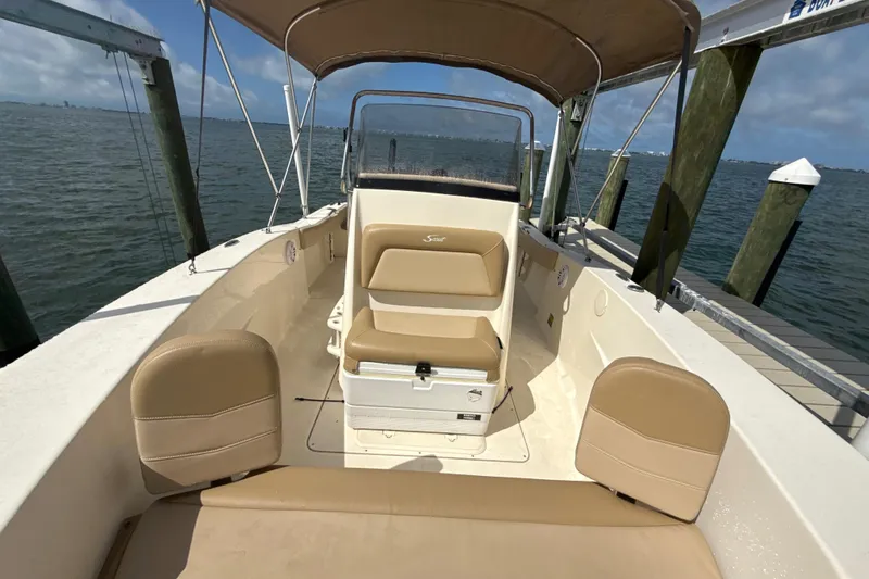 Slide: The Image of 2021 Scout 195 Sportfish boat with tan seating, docked by the water. - 9