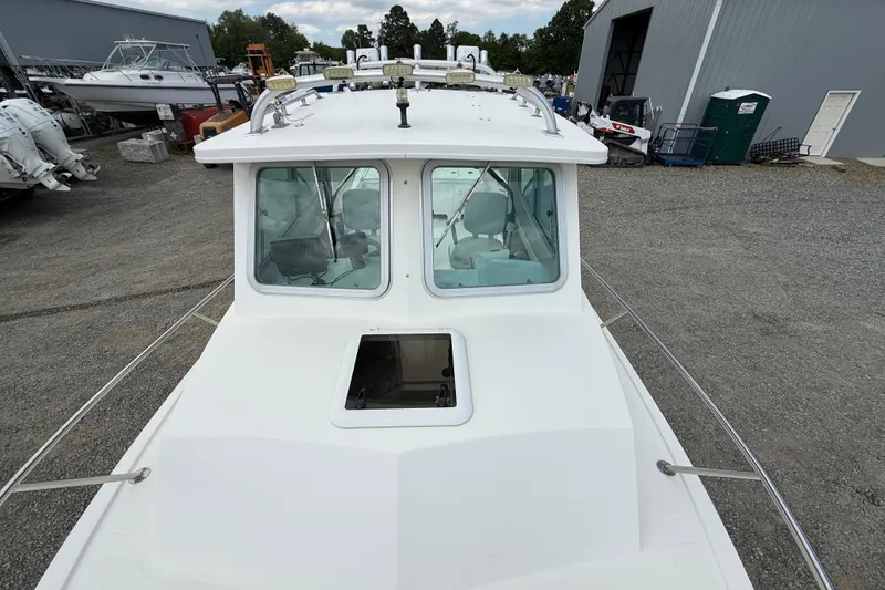 Slide: The Image of 2013 Steiger Craft 23 Miami boat on display at a marina, showcasing its cabin and deck. - 11