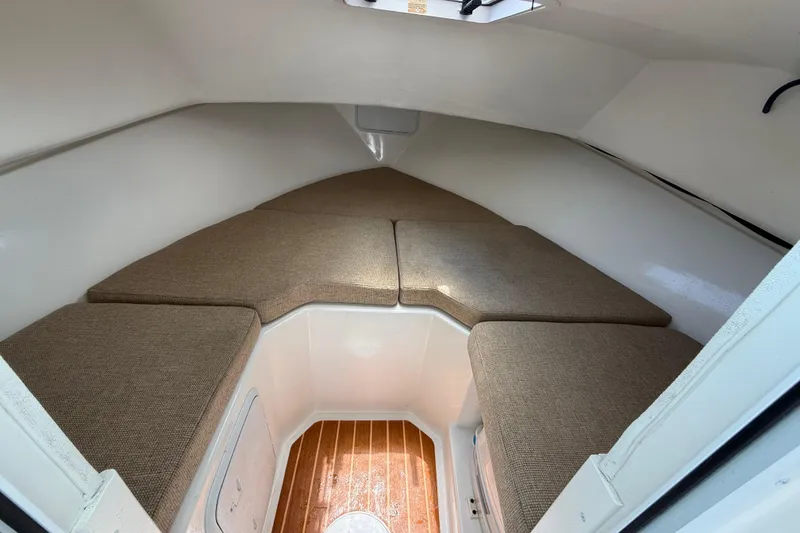 Slide: The Image of 2013 Steiger Craft 23 Miami cabin interior with cushioned seating and wooden flooring. - 14