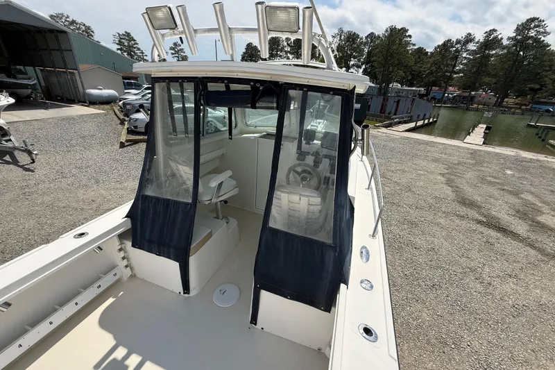 Slide: The Image of 2013 Steiger Craft 23 Miami boat docked, featuring enclosed cabin and spacious deck. - 15