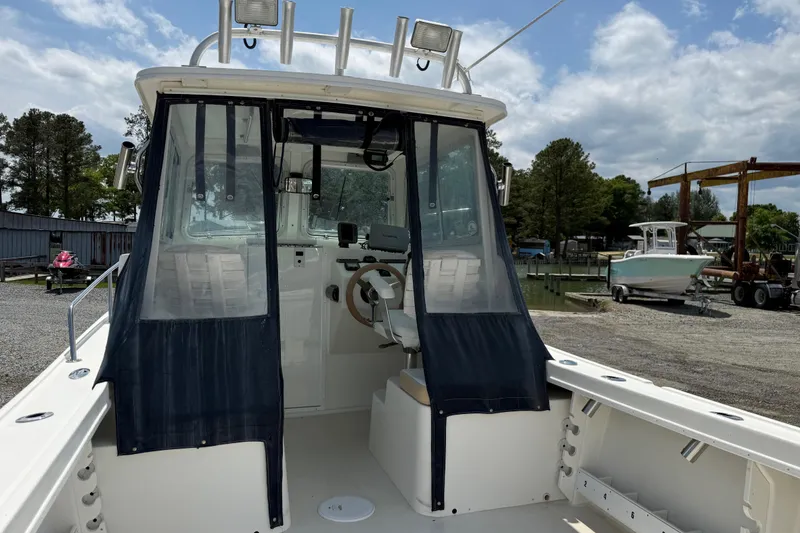 Slide: The Image of 2013 Steiger Craft 23 Miami boat with enclosed cabin, docked outdoors under cloudy sky. - 20