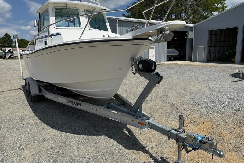 Slide: The Image of 2013 Steiger Craft 23 Miami boat on trailer, parked outdoors near a garage. - 22