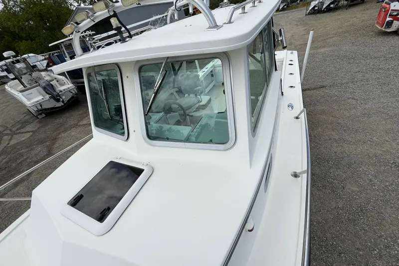 Slide: The Image of 2013 Steiger Craft 23 Miami boat with enclosed cabin, docked on gravel surface. - 9