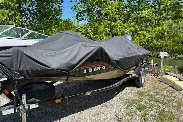 Slide: The Image of 2011 G3 Eagle 180 boat covered, parked on trailer near trees and water. - 13