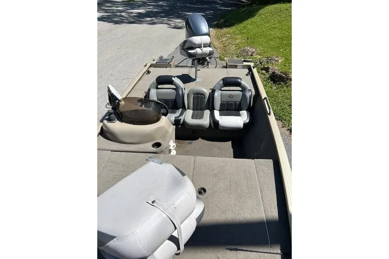 Slide: The Image of 2011 G3 Eagle 180 boat interior with seating and steering console, parked on a sunny day. - 5