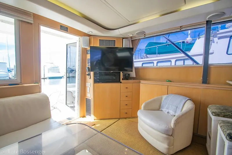 Slide: The Image of Interior of 1993 Tiara Yachts 4300 Convertible with TV, seating, and marina view. - 11