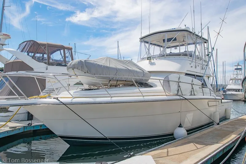 Slide: The Image of 1993 Tiara Yachts 4300 Convertible docked at marina under clear sky. - 2