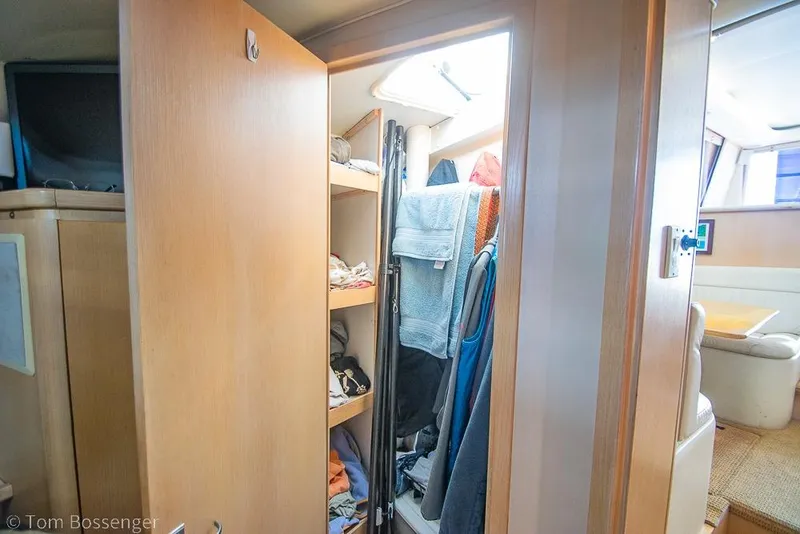 Slide: The Image of Interior of 1993 Tiara Yachts 4300 Convertible showing a closet with shelves and clothes. - 30
