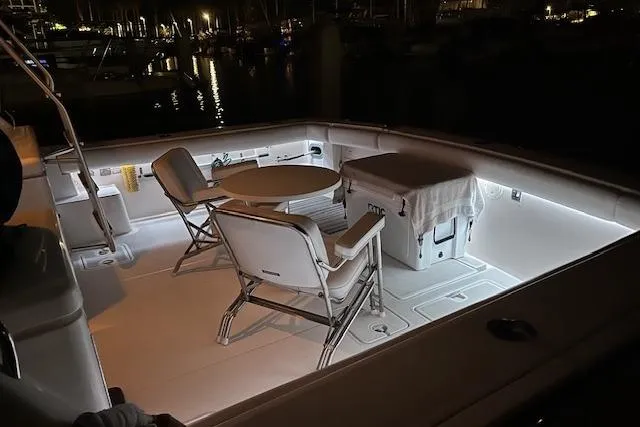 Slide: The Image of 1993 Tiara Yachts 4300 Convertible deck with chairs and table, illuminated at night. - 34