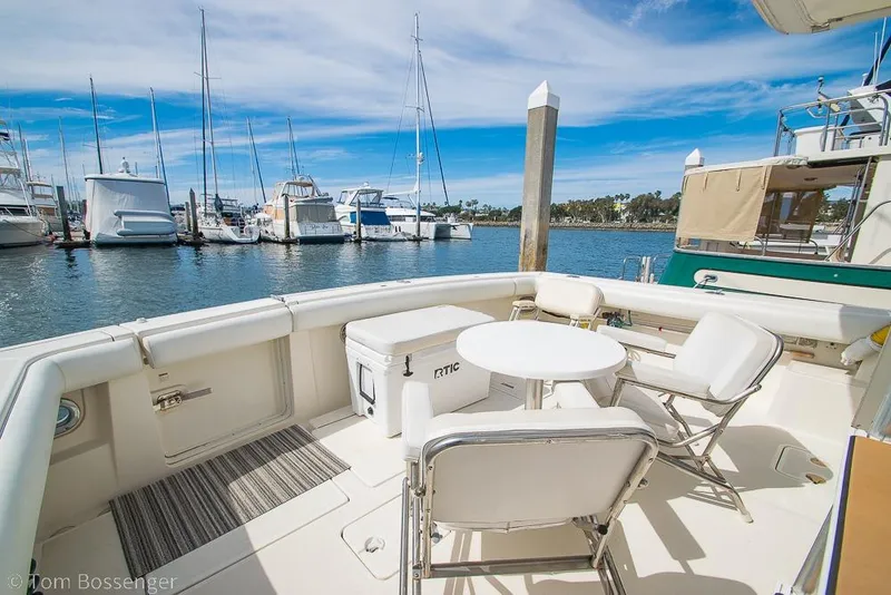 Slide: The Image of 1993 Tiara Yachts 4300 Convertible yacht deck with seating and table, docked at marina. - 36