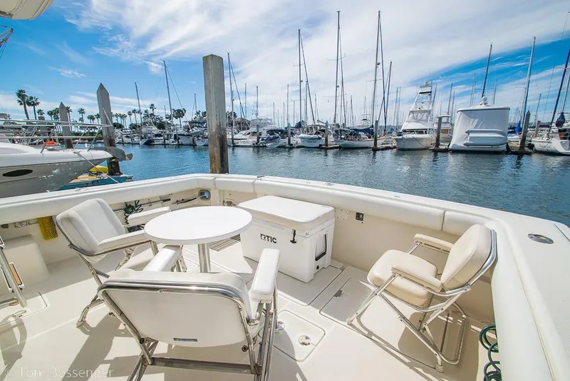 Slide: The Image of 1993 Tiara Yachts 4300 Convertible at marina, featuring deck chairs and table. - 37