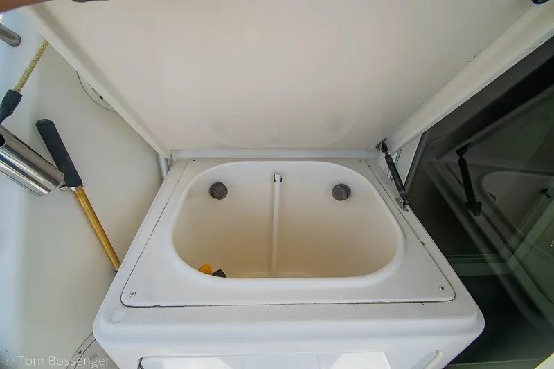 Slide: The Image of 1993 Tiara Yachts 4300 Convertible sink with storage compartment, featuring a clean, white design. - 38