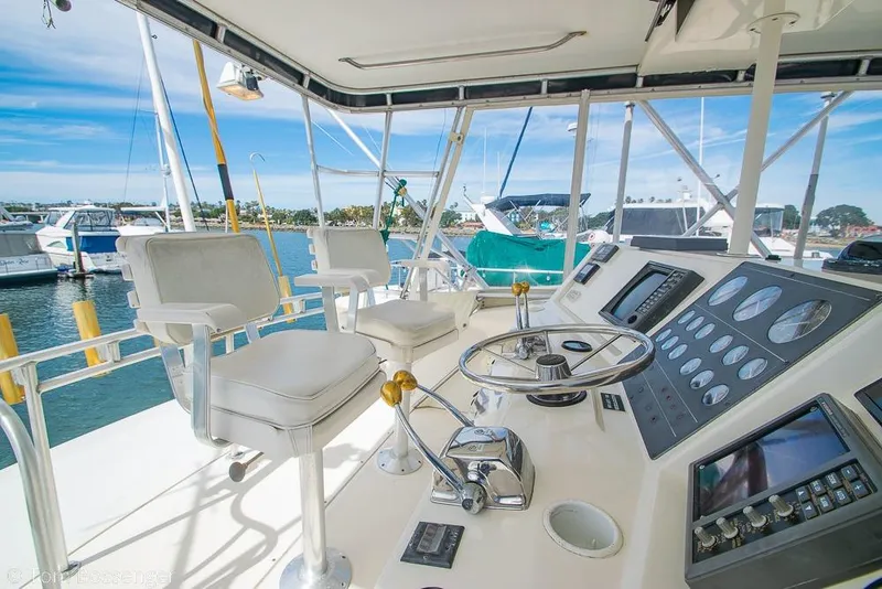 Slide: The Image of Cockpit of 1993 Tiara Yachts 4300 Convertible with helm and seating, docked at marina. - 41
