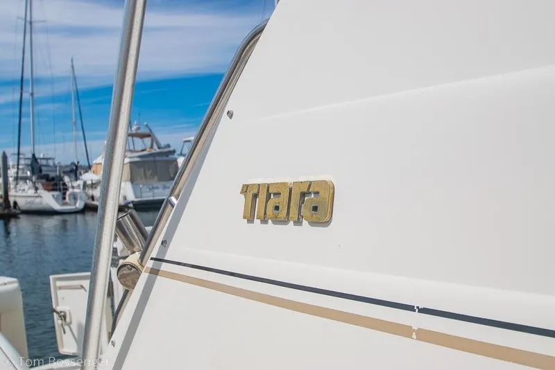 Slide: The Image of 1993 Tiara Yachts 4300 Convertible docked at marina, showcasing sleek design and branding. - 5
