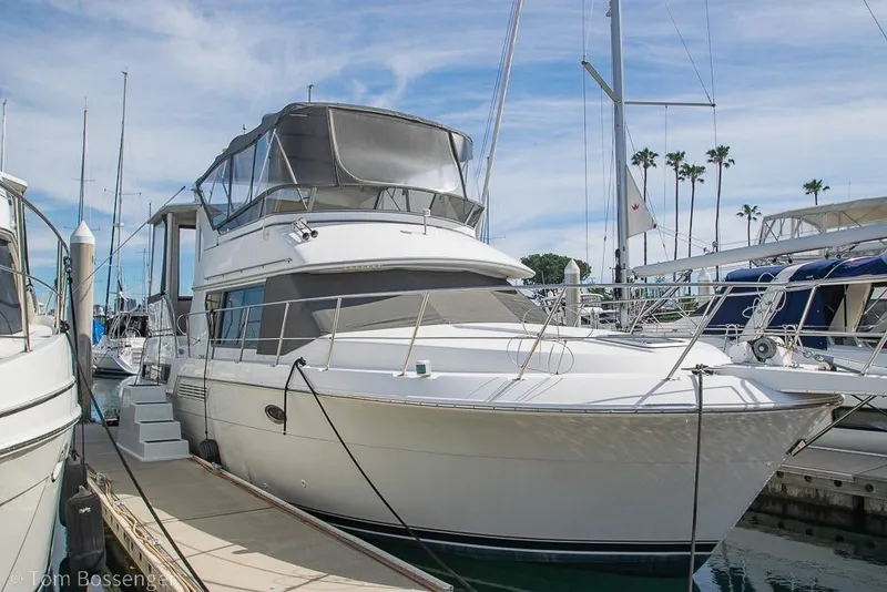 The Image of 1996 Carver 370 Aft Cabin Motor Yacht docked at marina under clear sky. - 1