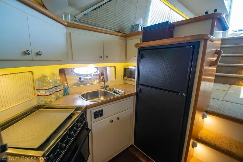 Slide: The Image of Compact kitchen in 1996 Carver 370 Aft Cabin Motor Yacht with stove, sink, and refrigerator. - 21
