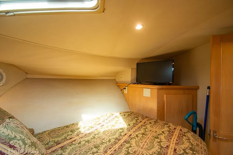 Slide: The Image of Cozy cabin interior of 1996 Carver 370 Aft Cabin Motor Yacht with TV and patterned bedding. - 31