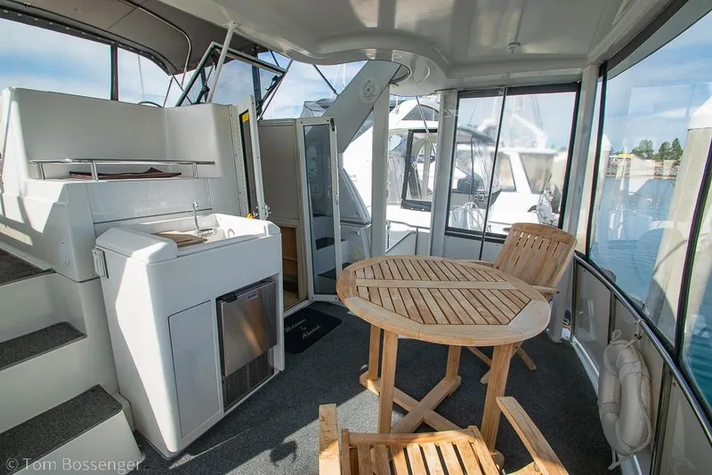 Slide: The Image of 1996 Carver 370 Aft Cabin Motor Yacht interior with wooden table and kitchenette. - 34