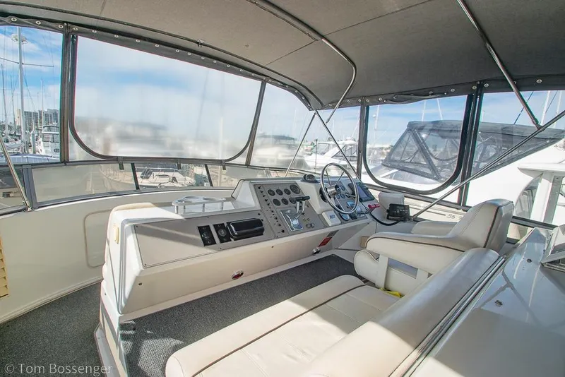 Slide: The Image of 1996 Carver 370 Aft Cabin Motor Yacht helm with modern controls and panoramic marina view. - 37
