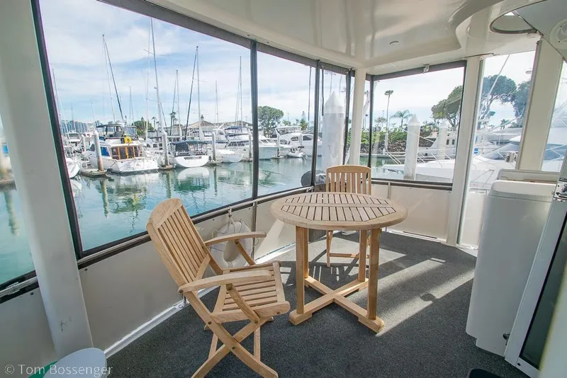 Slide: The Image of 1996 Carver 370 Aft Cabin Motor Yacht interior with wooden chairs and marina view. - 4