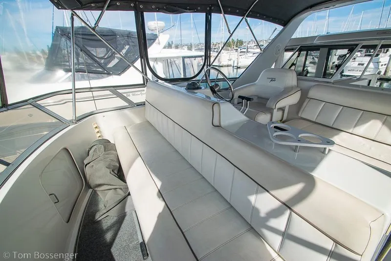 Slide: The Image of 1996 Carver 370 Aft Cabin Motor Yacht interior with helm, seating, and marina view. - 40