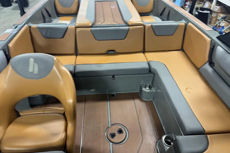 Slide: The Image of 2020 Heyday WT-2DC boat interior with tan and gray seating, cup holders, and deck flooring. - 11