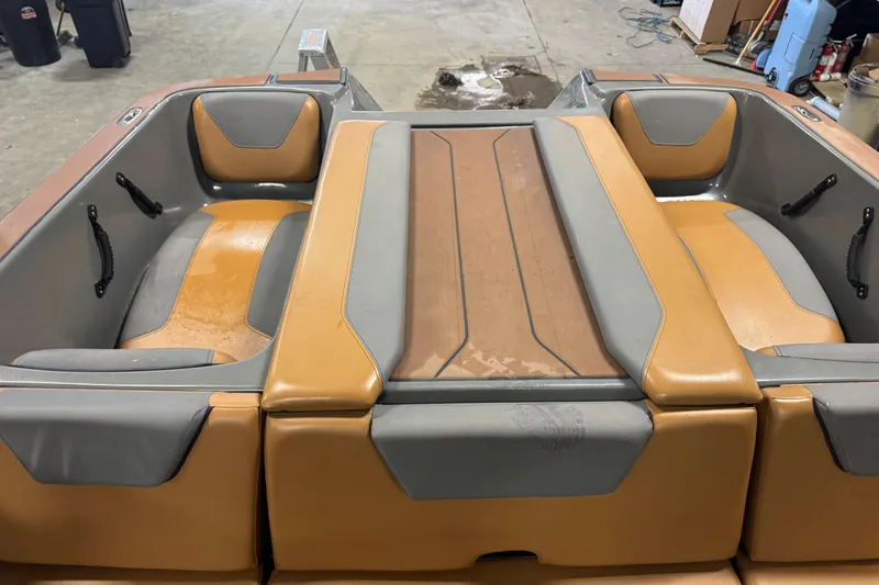 Slide: The Image of 2020 Heyday WT-2DC boat interior with tan and gray seating in a garage setting. - 12
