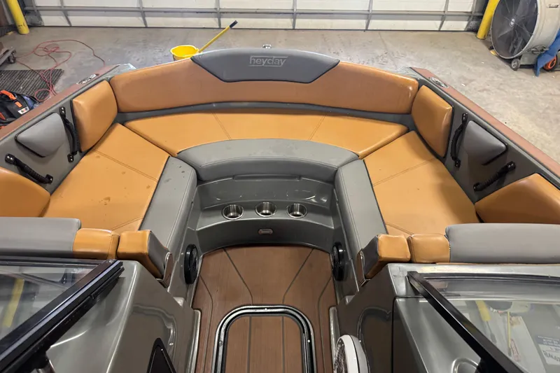 Slide: The Image of 2020 Heyday WT-2DC boat interior with tan and gray seating in a garage setting. - 9