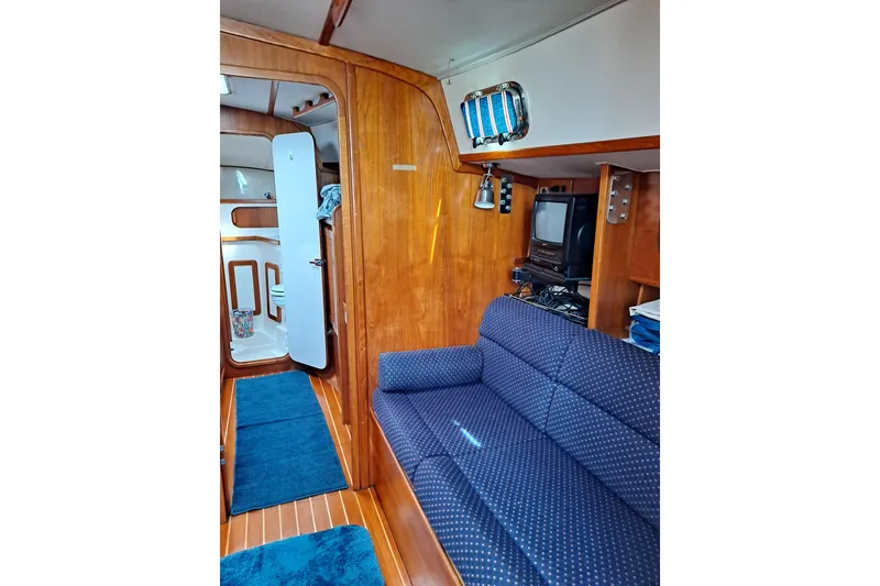 Slide: The Image of Interior of a 1998 Caliber 40LRC yacht with blue sofa and wooden paneling. - 10