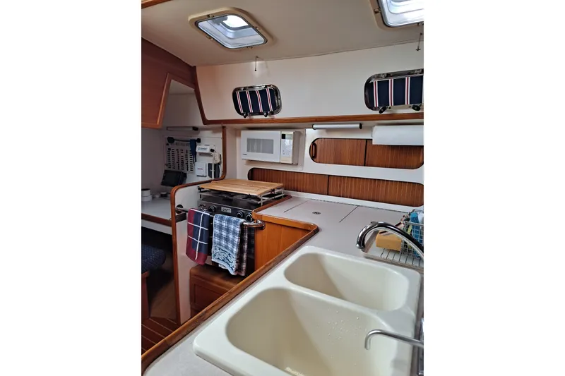Slide: The Image of Interior of 1998 Caliber 40LRC yacht kitchen with stove, sink, and wooden cabinetry. - 12