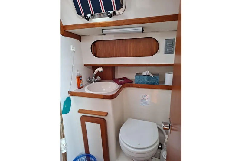 Slide: The Image of 1998 Caliber 40LRC yacht bathroom with sink, toilet, and wooden accents. - 16