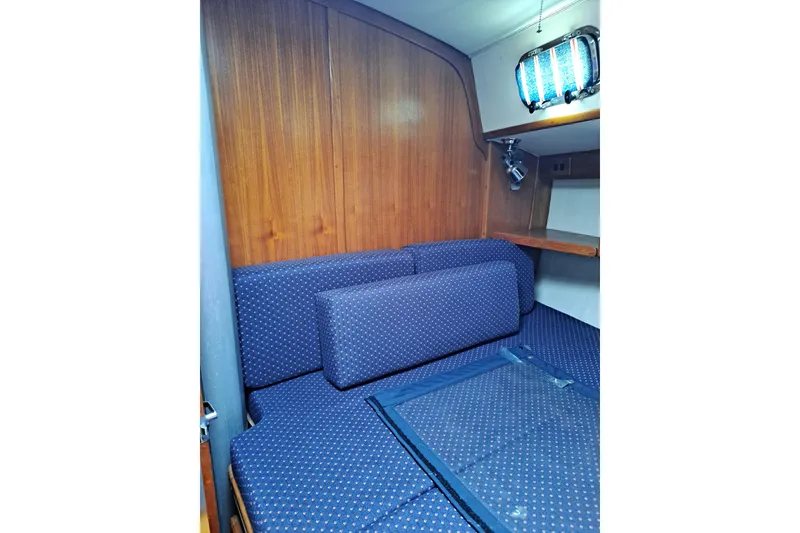 Slide: The Image of Interior cabin of 1998 Caliber 40LRC yacht with blue upholstery and wooden paneling. - 18