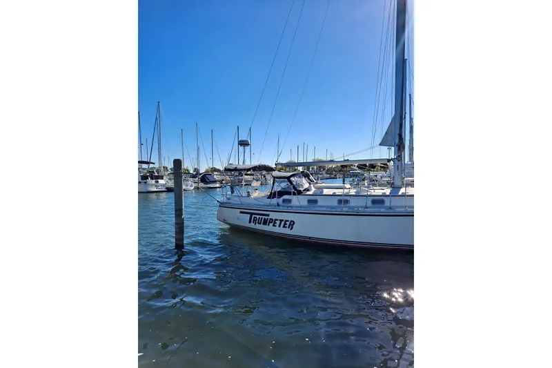 Slide: The Image of Sailboat "Trumpeter" docked in marina, Caliber 40LRC, 1998 model, under clear blue sky. - 6