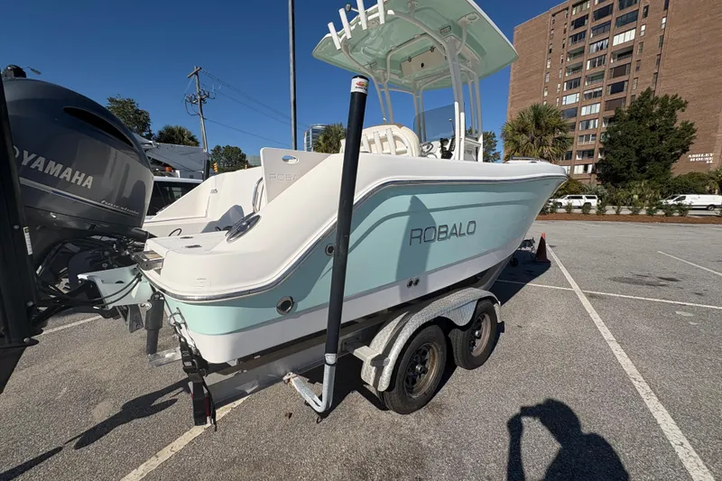 Slide: The Image of 2017 Robalo R222 boat on trailer, parked in urban setting, with Yamaha engine. - 17