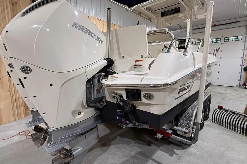 Slide: The Image of 2022 Boston Whaler 270 Dauntless boat with Mercury outboard engine in a garage. - 2